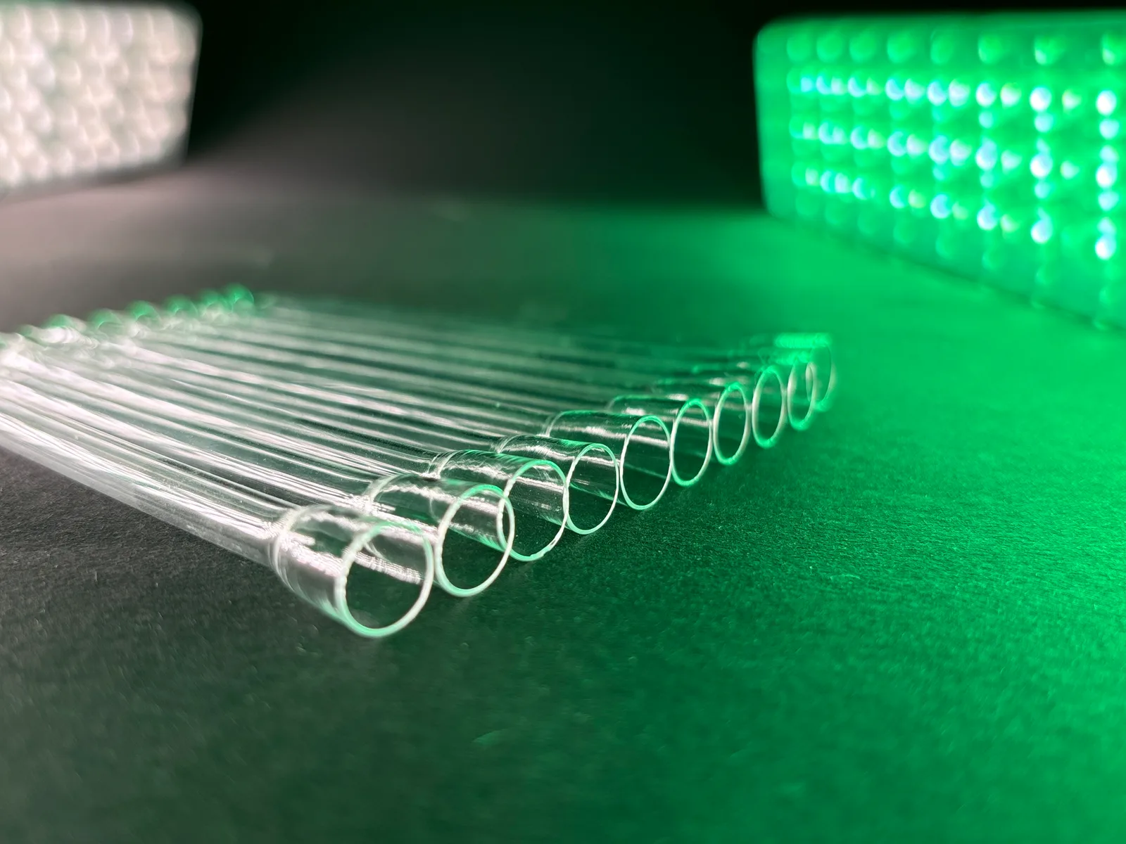Close-up of BUXI glass one-hitters in green light